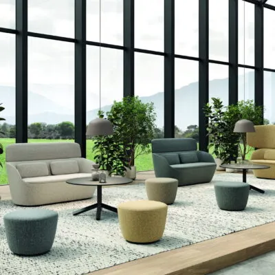 Hotel furniture: upholstered sofas, armchairs and poufs in a lounge with panoramic windows