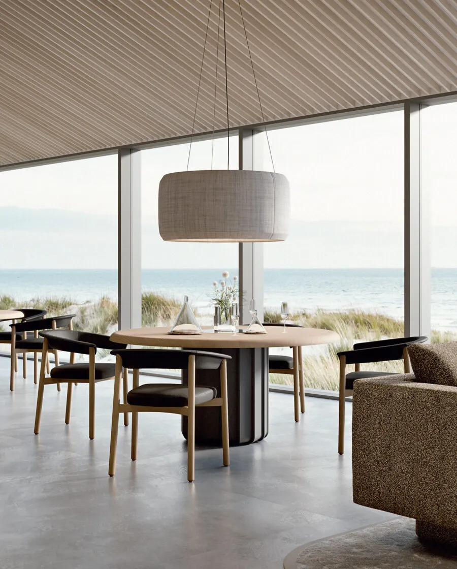 Lash chaise de design en bois noire autour d'une table ovale noire dans un espace côtier avec vue sur la mer et les dunes — design italien Sabree