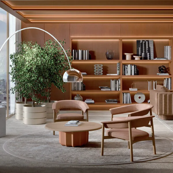 Lash wooden chairs design collection: Lounge Chair and Chair in blush pink fabric with oak frame, paired with a coffee table in a luxury executive living room with bookcase and city view &mdash; Frezza