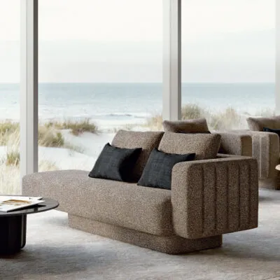 Sabree luxury sofa in taupe upholstery with blue cushions in a coastal living room with floor-to-ceiling windows and sea view — Italian design