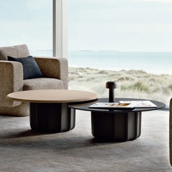 Table basse design italien Sabree, base sculptural noire et plateau chêne, dans un living côtier avec vue sur les dunes — design contemporain