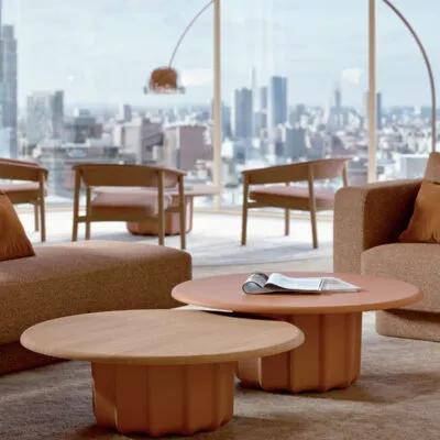 Sabree luxury coffee tables in two heights with oak and terracotta-toned round tops in a contemporary living room with city skyline view — Italian design