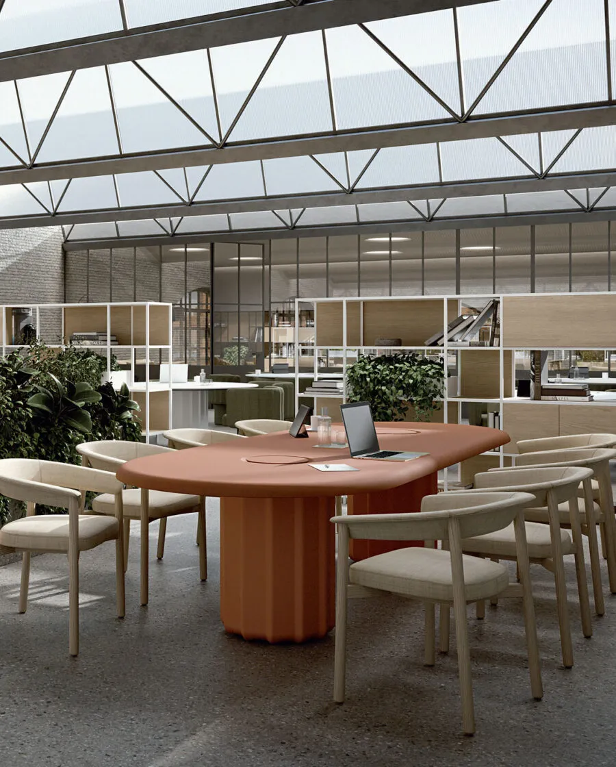 Table ovale design Sabree avec pieds centraux terracotta et chaises Lash dans un espace coworking loft avec verrière et étagères modulaires — Frezza contract