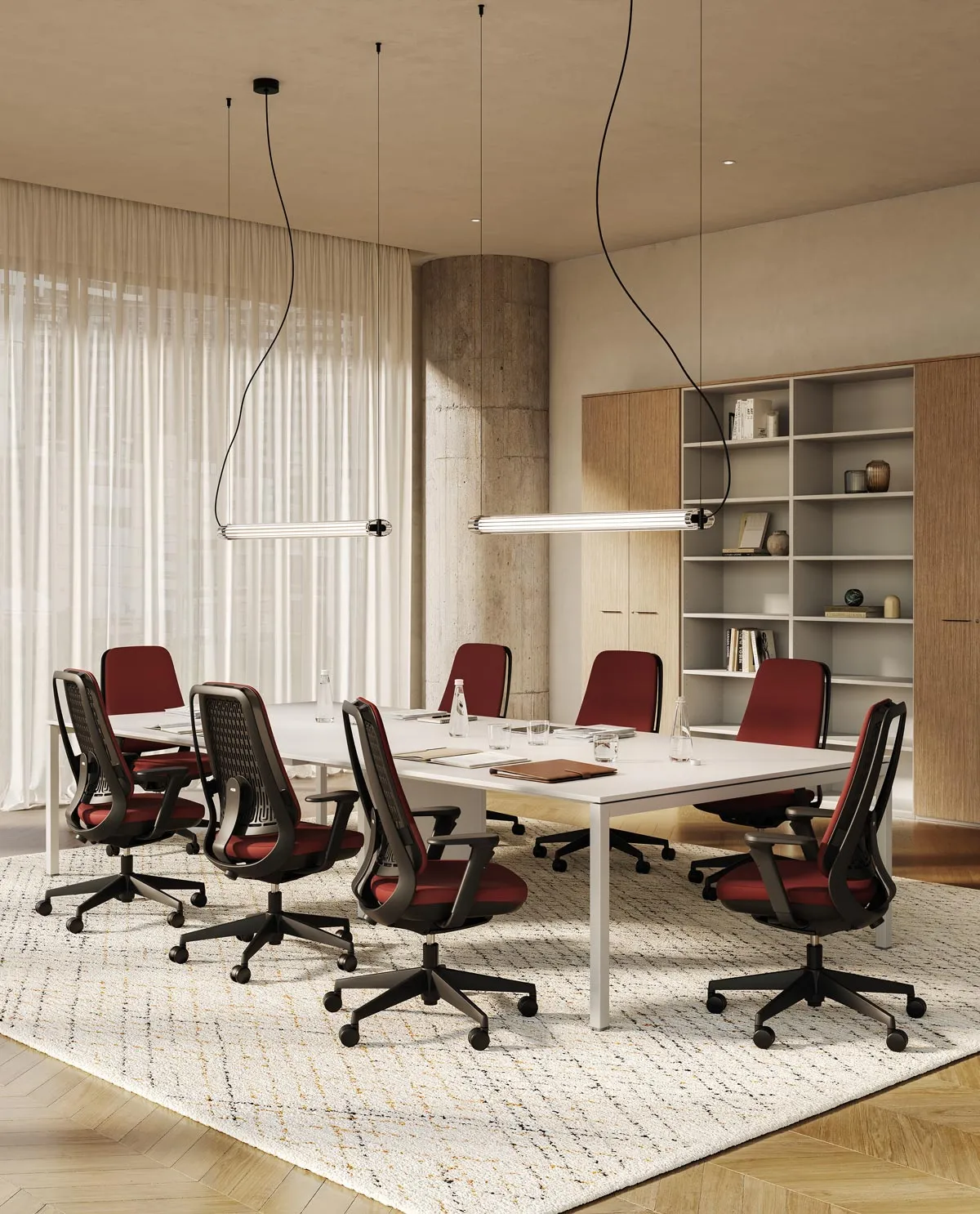 Sedie ufficio ergonomiche Areca Fabric rivestite in tessuto rosso attorno a un tavolo riunioni bianco, in un ufficio con tende e libreria in legno