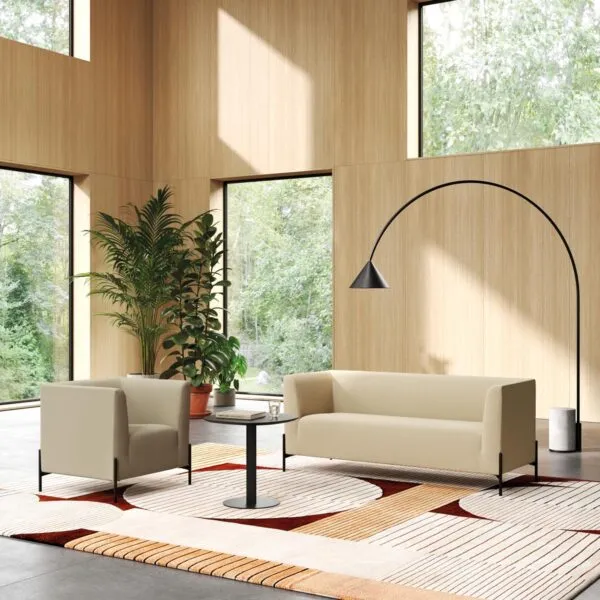 Clint beige fabric armchair and three-seater sofa for office waiting areas, in a double-height space with wooden walls and large windows